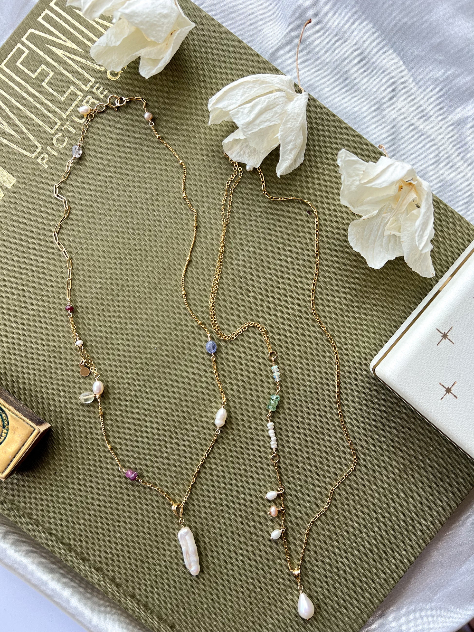 Left chain featuring a long stick pearl. Right chain featuring a teardrop pearl.